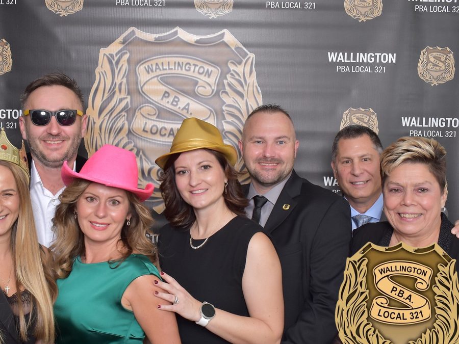 Guests posing at a branded step-and-repeat photo booth backdrop for a New Jersey organization event
